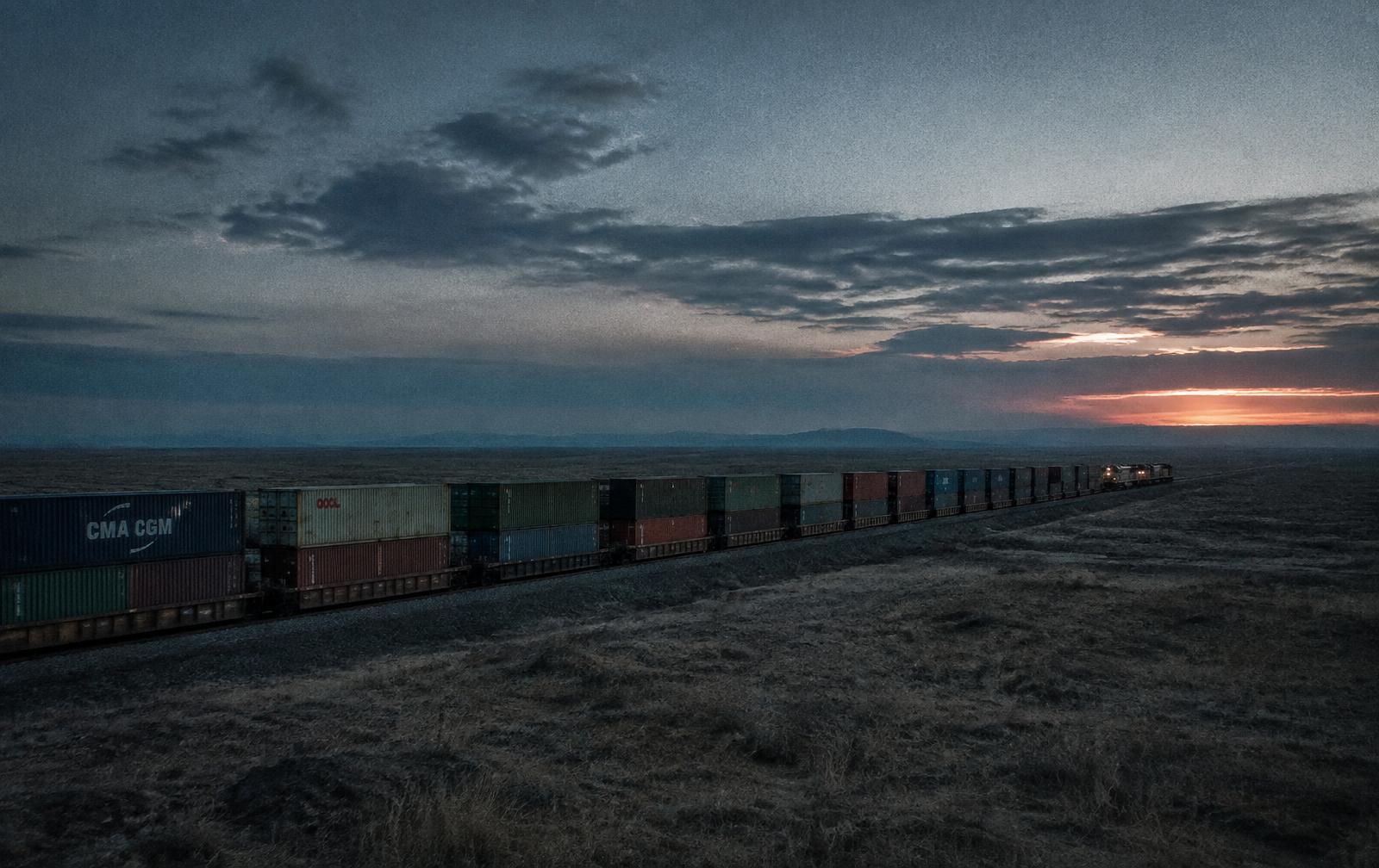Container freight train crossing open landscape